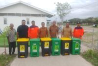 Dinas Lingkungan Hidup (DLH) Pidie Jaya menyerahkan bantuan tong sampah kepada warga di Huntara Cot Trieng. Foto : Ist